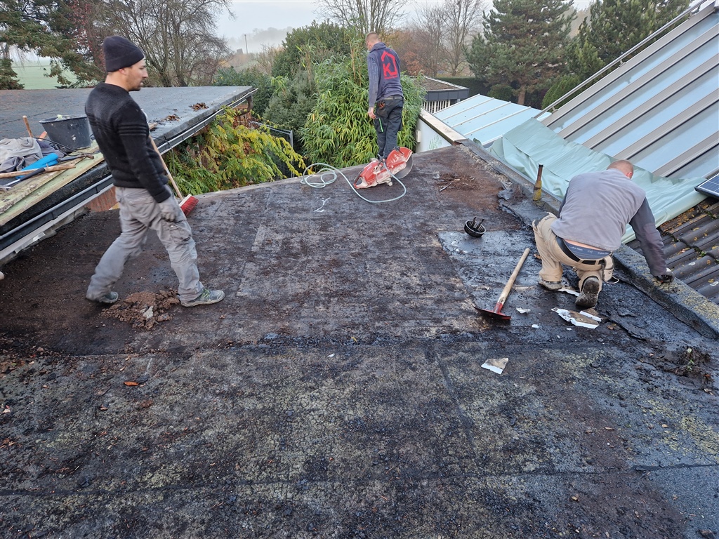 Handwerker bei Sanierungsarbeiten auf einem Flachdach