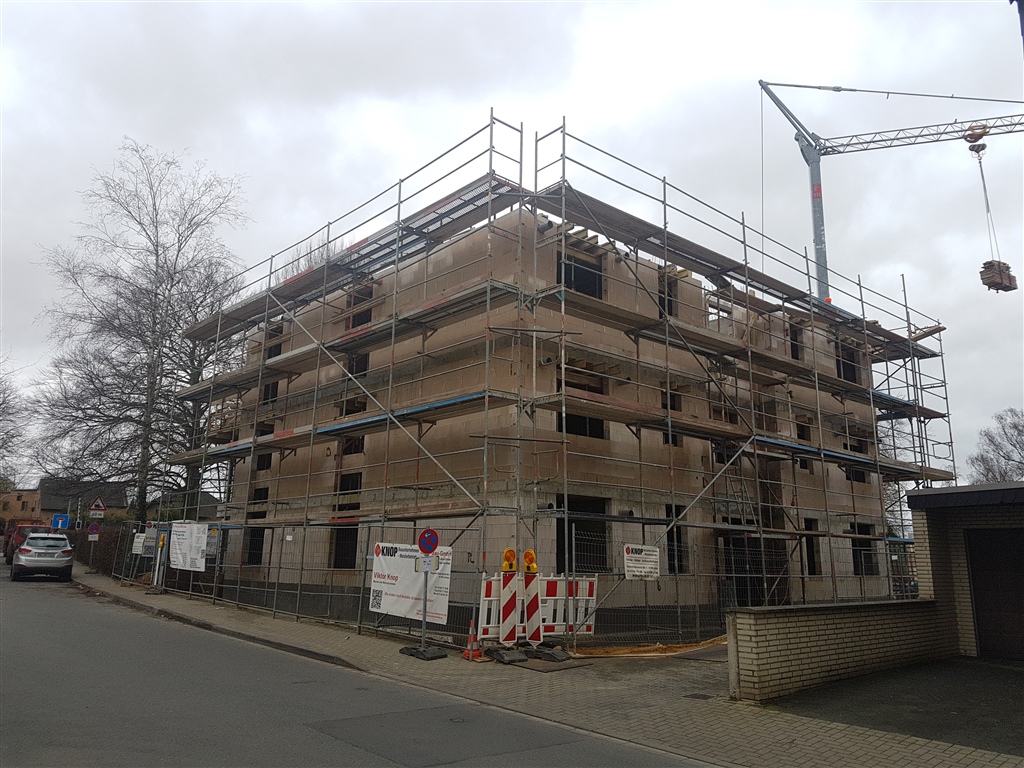 Eingerüstetes Mehrfamilienhaus im Rohbau