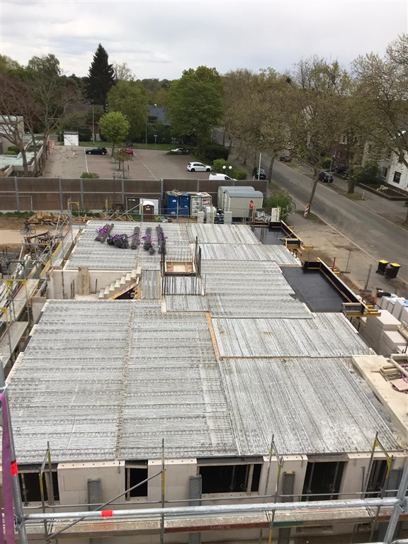 Betondecke im Rohbau mit Kran über der Baustelle