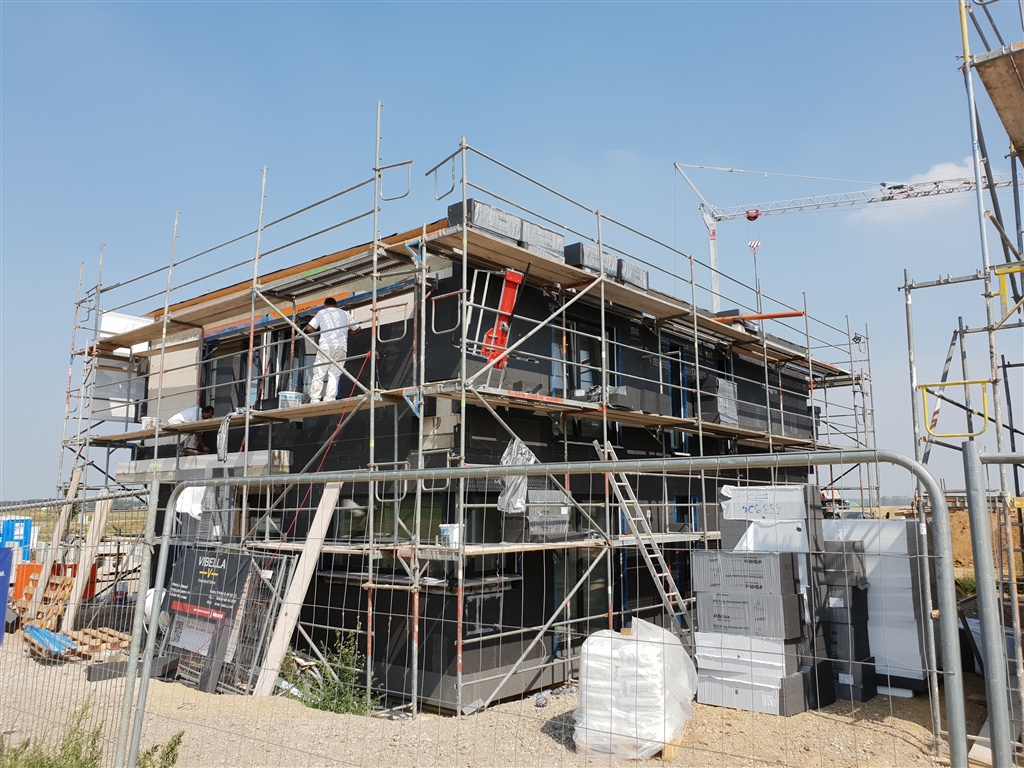 Eingerüstete Fassade eines mehrgeschossigen Neubaus